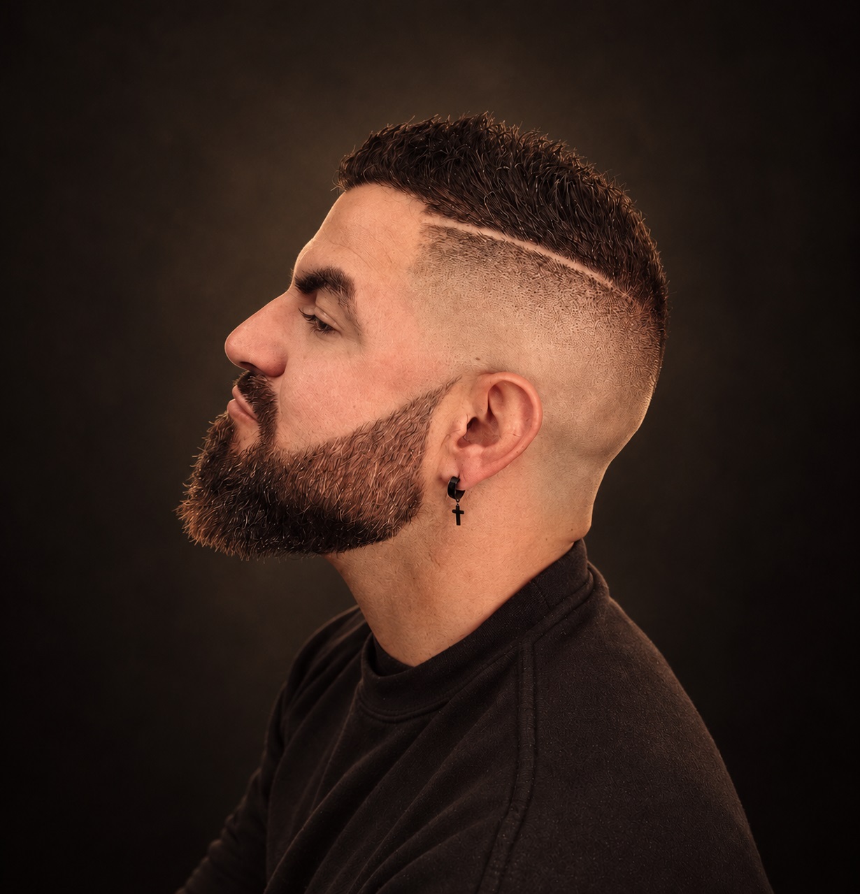 Man with a dark beard and a sharp surgical line fade